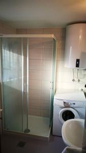 La salle de bains est pourvue d'une douche avec une porte en verre. dans l'établissement Quiet getaway house, à Sečovlje