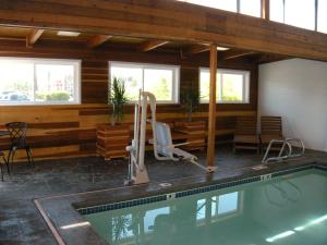 a swimming pool in a room with a house at Motel West in Idaho Falls