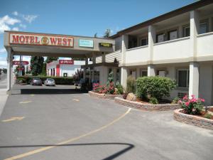 
a street scene with cars parked in front of a building at Motel West in Idaho Falls
