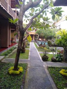 einen Gehweg in einem Innenhof mit Bäumen und Pflanzen in der Unterkunft Merthayasa Bungalows in Ubud
