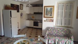 a small kitchen with a table and a refrigerator at Appartamento Bouganville in Magomadas +27 photos
