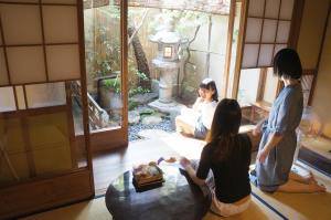 eine Gruppe von Personen, die in einem Wohnzimmer sitzen in der Unterkunft Guesthouse Itoya Kyoto in Kyoto