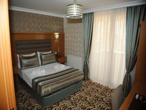 A bed or beds in a room at Alfa Hotel