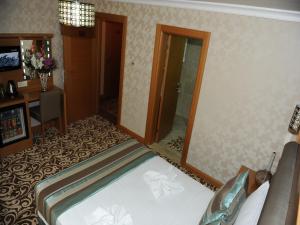 A bed or beds in a room at Alfa Hotel