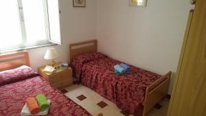 a small bedroom with two beds and a window at Appartamento Bouganville in Magomadas