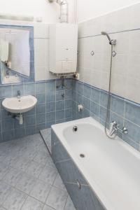 uma casa de banho com uma banheira e um lavatório em Anker Apartman Kaposvár em Kaposvár