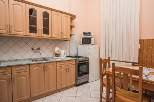 a kitchen with wooden cabinets and a white refrigerator at Anker Apartman Kaposvár in Kaposvár
