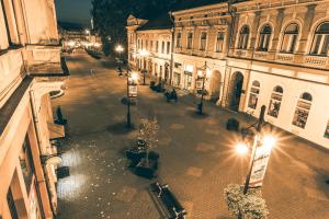 uma rua da cidade vazia à noite com luzes de rua em Anker Apartman Kaposvár em Kaposvár