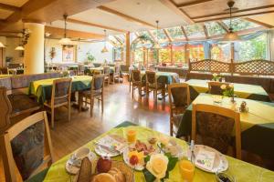 a dining room with tables and chairs with yellow tablecloths at Land-gut-Hotel Landgasthof Zum Schildhauer in Halfing