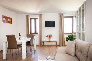 ein Wohnzimmer mit einem Tisch und einem Sofa in der Unterkunft Ondina 2 in Rovinj