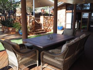 einen Holztisch und Stühle auf einer Terrasse in der Unterkunft Wilmots on Dixon in Alice Springs