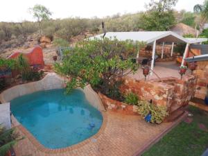 uma grande piscina num quintal com um pátio em Wilmots on Dixon em Alice Springs