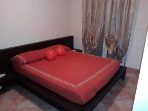 a red bed with two red pillows on top of it at Appartamento Iolanda in Tortoreto Lido