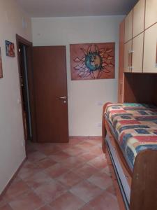 a bedroom with a bed and a painting on the wall at Appartamento Iolanda in Tortoreto Lido
