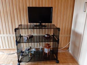 una TV su una mensola in vetro con tv di Jenny's house,Agiou Ioannou 103 a Artemida