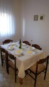 a table with a white table cloth and a bottle of wine at Apartmani Ante in Posedarje