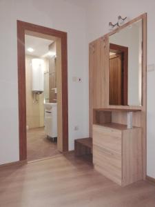 een badkamer met een grote spiegel en een houten dressoir bij Studio Paradise in Veliko Tŭrnovo