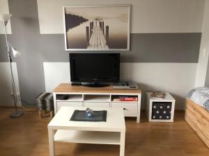 een woonkamer met een tv en een witte salontafel bij City Weserblick in Bremerhaven