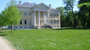 a large white house with columns on a field of grass at Ferienhaus Wittig in Löbnitz