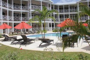 a hotel with a pool and chairs and umbrellas at Lantana Resort Barbados by Island Villas in Saint James