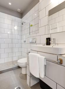 a white bathroom with a sink and a toilet at Colors Ladadika Thessaloniki in Thessaloniki