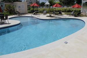 a large blue swimming pool with chairs and umbrellas at Lantana Resort Barbados by Island Villas in Saint James