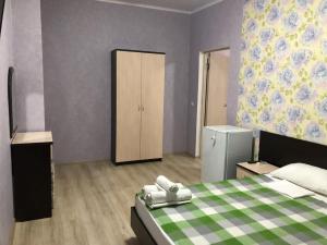 ヴィチャゼヴォにあるГостевой дом Субмаринаのベッドルーム1室(緑と白の毛布付きのベッド1台付)