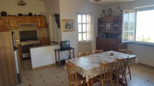 a kitchen with a table with chairs and a television at Attico Bouganville in Magomadas