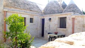 a house with a table in front of it at Trulli e Cummerse in Locorotondo