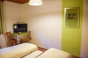 a room with a bed and a table and a tv at Gasthof Gruber in Wald am Schoberpaß