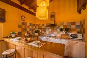 cocina con paredes amarillas y encimera de madera en CASUCAS LA GUARIZA - Casa Susi - en Fontibre