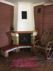 a brick fireplace with a bench and a chair at Dukatówka in Lubycza Królewska