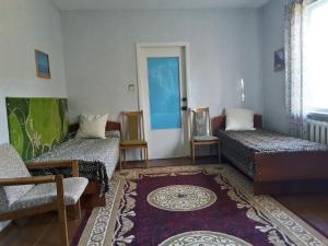 a room with two beds and a chair and a door at Guest house Elena in Kaji-Say