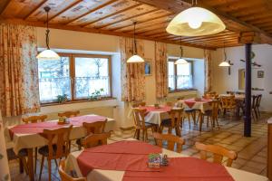 a restaurant with tables and chairs and windows at Gasthof Gruber in Wald am Schoberpaß