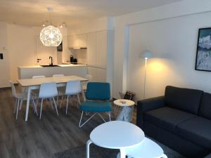 un soggiorno con divano, tavolo e sedie di New Port apartment a Nieuwpoort