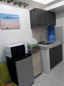 een kleine keuken met een spoelbak en een magnetron bij Standard Room with Balcony 1569 in Tagaytay