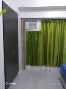 een kamer met een groen gordijn en een raam bij Standard Room with Balcony 1569 in Tagaytay +13 foto's