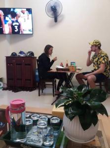 two people sitting at a table in a room at Guest House Maika in Hue