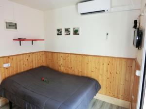 a bedroom with a bed in a room with wood paneling at Rosesapparts Estudios & Parking in Roses