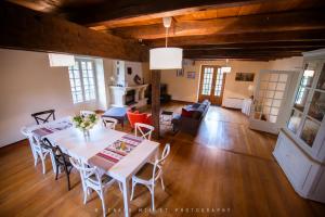 ein Esszimmer und ein Wohnzimmer mit einem Tisch und Stühlen in der Unterkunft Le Moulin de Bois Coûtant in Vivonne