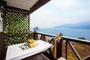 - une table sur un balcon avec vue sur l'océan dans l'établissement oneday in geoje, à Geoje