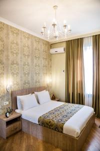 sypialnia z dużym łóżkiem i żyrandolem w obiekcie Dat Exx Apartments w mieście Tbilisi City