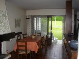 ein Esszimmer mit einem Tisch und Stühlen sowie eine Küche in der Unterkunft L'Onyx - Domaine de Nant Cruy in Sallanches