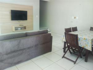 ein Wohnzimmer mit einem Sofa und einem Tisch in der Unterkunft Residence Delux Flecheiras in Flecheiras
