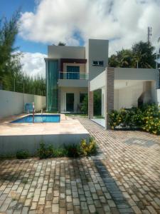 una casa con una piscina di fronte di Residence Delux Flecheiras a Flecheiras