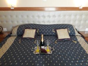 a bed with a bottle of wine and two glasses at Studios Cosmopolitan in Panagioúda
