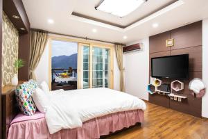 1 dormitorio con cama grande y ventana grande en oneday in geoje en Geoje 