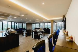 un ristorante con un lungo tavolo e sedie blu di The Aristo by Holy Cow, 2-BR, 60 m2, pool view a Surin Beach Altre 27 foto