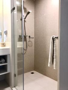 un bagno con doccia con porta in vetro di The Aristo by Holy Cow, 2-BR, 60 m2, pool view a Surin Beach