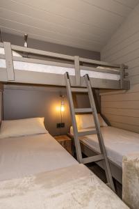 プッチェルダーにあるBungalows Stel-Puigcerdàのランプ付きのドミトリールームの二段ベッド2台